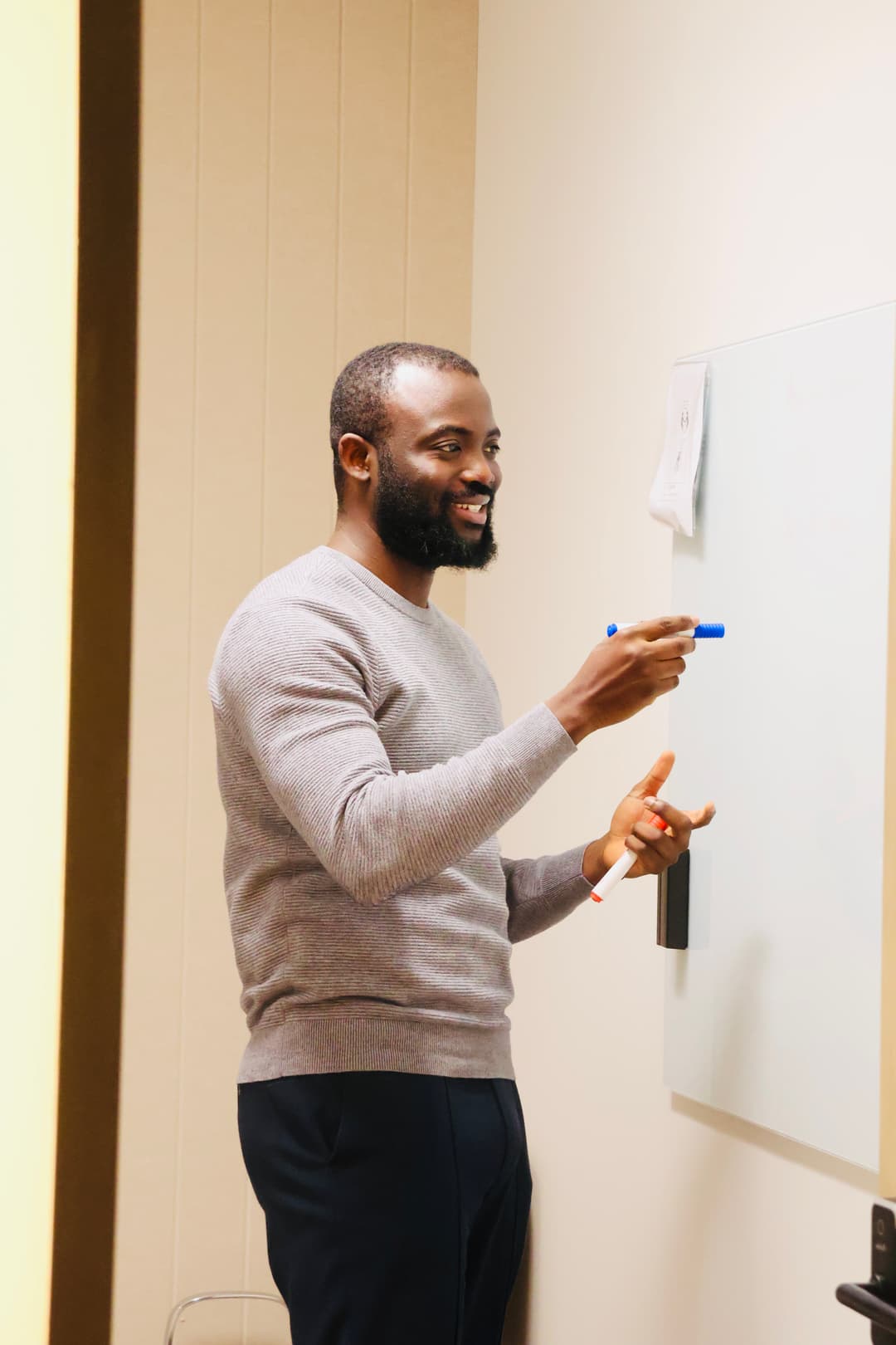Noah Oloja teaching AI at whiteboard